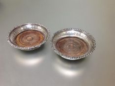 A pair of 19th century silver-plated bottle coasters, each with turned mahogany base within a