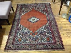 An Iranian rug, the central panel with stylised diamond design enclosed within a multiple flower and