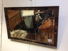 A 1920's black Chinoiserie framed wall mirror, the rectangular bevelled plate within a conforming