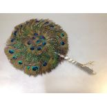 A peacock feather fan, c. 1900, circular, with bound handle. Length 37cm