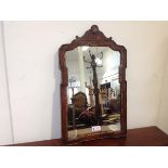 A George II parcel-gilt walnut wall mirror, the shaped moulded frame enclosing a gilt slip and