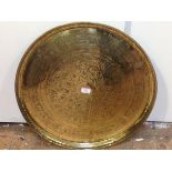 A Middle Eastern brass tray, circular, the well with central roundel of star design enclosing