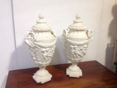 A pair of large composition urns in the Neoclassical taste, each stepped domed cover with berry