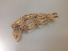 A 9ct gold fancy chainlink bracelet, formed of seven four-bar panels, on a heart padlock clasp, with