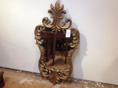 A giltwood Rococo style mirror, the cartouche shaped plate within a conforming frame boldly carved