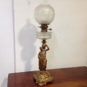 A late 19th century gilt-metal figural oil lamp, modelled as a Classical female water carrier, on