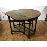 An 18th century oak gate leg table, the oval top (loss to one end) above a plain frieze, raised on