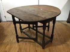 An 18th century oak gate leg table, the oval top (loss to one end) above a plain frieze, raised on