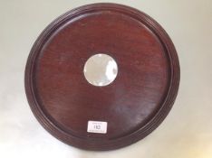 A silver-mounted mahogany drinks tray, the circular tray with reeded rim centred by a silver disc (