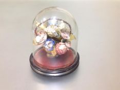 A Victorian shell work ornament, modelled as a basket of polychrome flowers, mounted on an