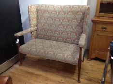 A mahogany framed upholstered wing back settle, possibly George III, the high back between full