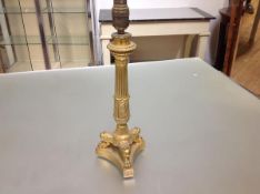 An Empire style gilt-bronze candlestick, converted to a table lamp, the fluted column cast with a