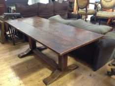 An Arts & Crafts oak refectory table, the planked top with cleated ends, raised on massive square