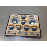 A Royal Worcester coffee service for six cased with six enamelled silver coffee spoons, the cups and