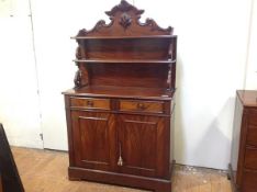 An early Victorian figured mahogany chiffonier, the superstructure with relief carved scrolling