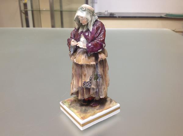 A 19th century Continental porcelain figure of a beggar worman, in Naples style, modelled in