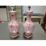 A pair of porcelain baluster vasiform table lamps, each decorated in the Chinese taste with coral