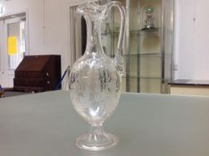 A 19th century acid-etched glass ewer, of slender baluster form, with elongated neck and loop handle