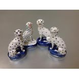 A group of five Staffordshire models of seated dalmatians, each on an oval blue base with gilt chain