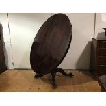 An early Victorian rosewood tilt-top breakfast table, c. 1840, the oval top with moulded edge and