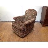 A small 1920's club chair, with arched upholstered back above a loose-cushioned seat between