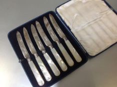 A cased set of six George V silver and mother of pearl butter knives, the silver blades hallmarked