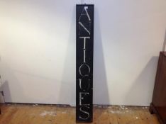 A vintage painted wooden shop sign, "Antiques", white on black. 154cm by 23cm