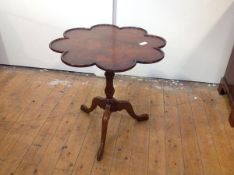 A George II style walnut tilt-top tripod table, the scalloped dished top above a birdcage and