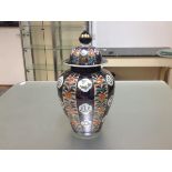A Japanese Imari porcelain baluster jar and cover, the domed cover and body decorated in panels