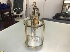 A French cast brass hall lantern light of cylinder form with acorn and bow mounted frame, with