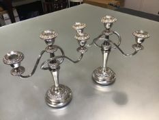 A pair of Epns three branch candelabra raised on circular moulded bases complete with drip trays (