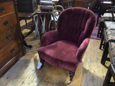 A Victorian walnut framed button back drawing room easy chair in faded plum velvet, on turned