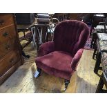 A Victorian walnut framed button back drawing room easy chair in faded plum velvet, on turned