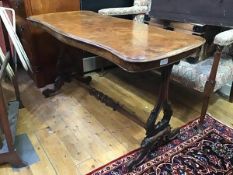 A Victorian walnut sofa table, the shaped top with moulded edge raised on twin end carved shaped