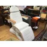 A modern oak framed electrically adjustable fully reclining massage and therapy chair upholstered in