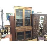 An Edwardian oak two part cabinet bookcase, the moulded cornice above a pair of glazed panel doors