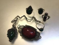 A collection of white metal jewellery mounted with green glass including rings, pendant, red glass