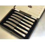 A set of six stainless steel mother of pearl handled side knives