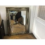 A modern silvered rococo style frame wall mirror with bevelled glass plate (118cm x 85cm)