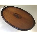 An Edwardian mahogany oval tray with scalloped border and twin brass handles to side (69cm x 45cm)