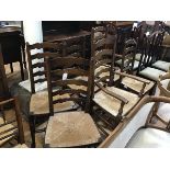 An oak gateleg drop leaf dining table and set of four plus two ladderback rush seat dining chairs,