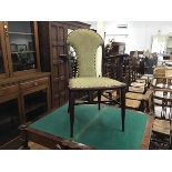 A stained upholstered panel back Edwardian open armchair with inset seat, on tapered supports (h.