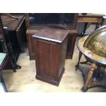 An Edwardian walnut ledgeback bedside/pot cupboard, the top with moulded edge above an inset panel