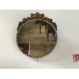 A 1930s barbola circular wall mirror with rose and leaf floral surmount and bevelled glass plate (