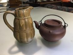 A Japanese pottery teapot with bronze style metal loop handle, signed to top and verso (10cm) and