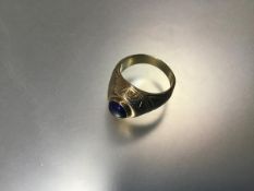 A heavy yellow metal unmarked American class style ring set coloured blue stone (11.85g) (T)