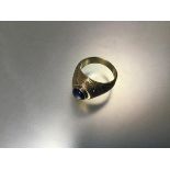 A heavy yellow metal unmarked American class style ring set coloured blue stone (11.85g) (T)