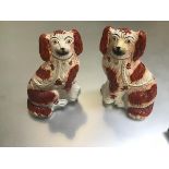 A pair of 19thc Staffordshire pottery chimney spaniels decorated with polychrome enamels (h.24cm x