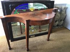 A 1930s figured walnut serpentine hall table with inlaid crossbanded supports, raised on tapered