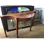 A 1930s figured walnut serpentine hall table with inlaid crossbanded supports, raised on tapered